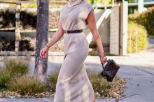 26 a grey sleeveless midi dress, a chain necklace, a brown belt, neutral Chelsea boots and a brown bag