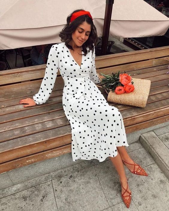 a white and black polka dot midi dress, red lace up shoes, a red headband and a straw bag