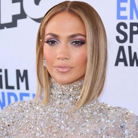 J.Lo wearing a sleek and straight blonde bob with a money piece and touches of balayage