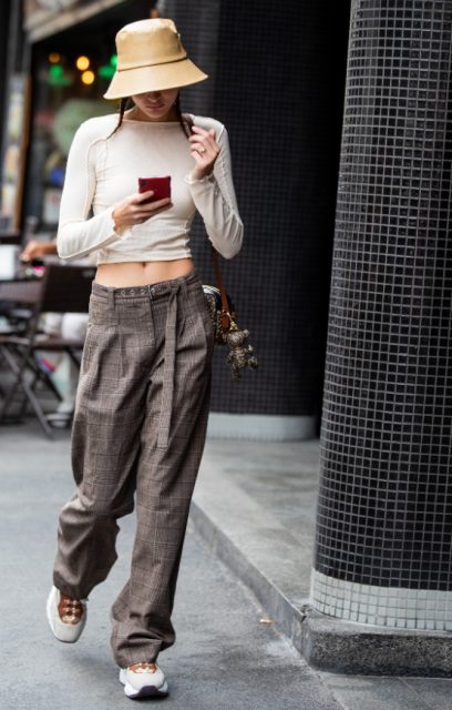 With beige cropped shirt, checked loose belted pants, bag and sneakers