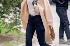 With beige turtleneck sweater, sunglasses, beige midi coat, black leather gloves and navy blue flare cropped jeans