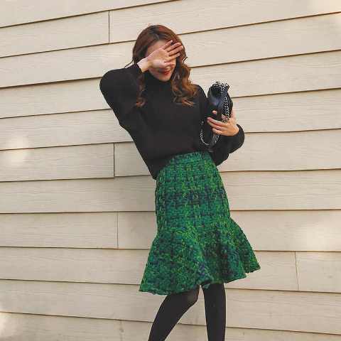 With black loose turtleneck sweater, black leather chain strap bag and black tights