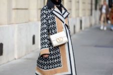 With black turtleneck, golden necklace, beige midi skirt, printed midi coat, white embellished bag and olive green lace up mid calf boots