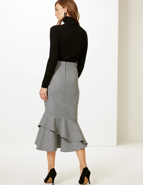 With earrings, black turtleneck sweater and black suede pumps
