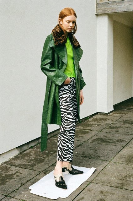 With green shirt, green leather knee-length coat with a leopard printed collar and black leather mules