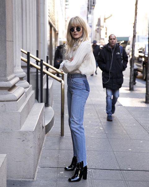 With rounded sunglasses, white loose blouse and light blue high-waisted distressed jeans