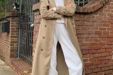With white hoodie sweatshirt, white jogger pants, beige maxi trench coat and beige lace up shoes