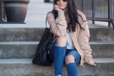 With white t-shirt, distressed jeans, sneakers, black leather tote bag, sunglasses and pale pink bomber jacket