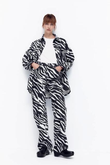 With white t shirt, zebra printed long jacket and black shoes