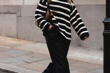 a black and white striped sweater, black trousers, navy sneakers and a camel tote