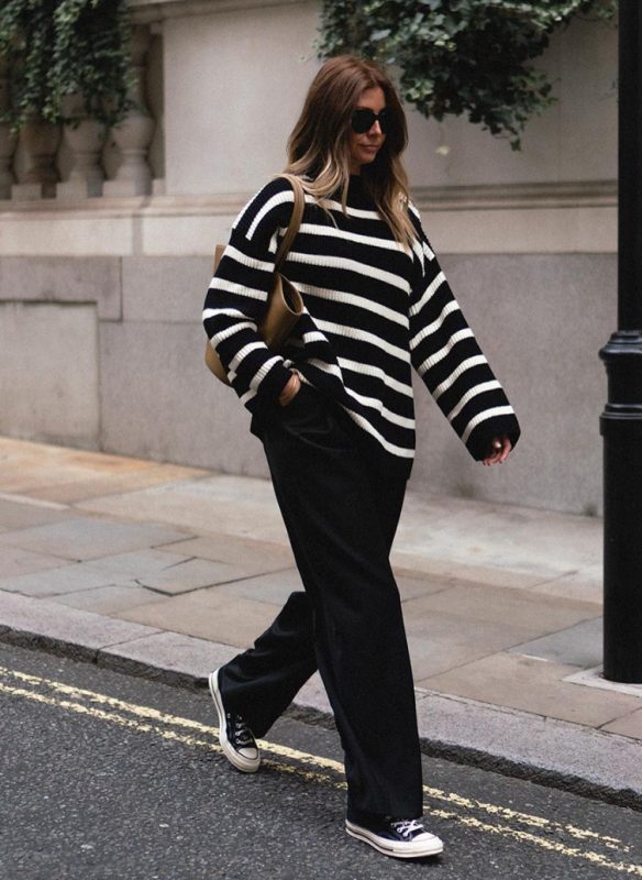 a black and white striped sweater, black trousers, navy sneakers and a camel tote