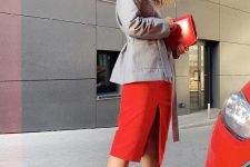 a grey jacket with a sash, a red midi skirt with a slit, a red bag and criss cross black shoes for work