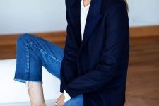 a timeless work outfit with a white tee, blue cropped jeans, black shoes, a navy oversized blazer and statement earrings