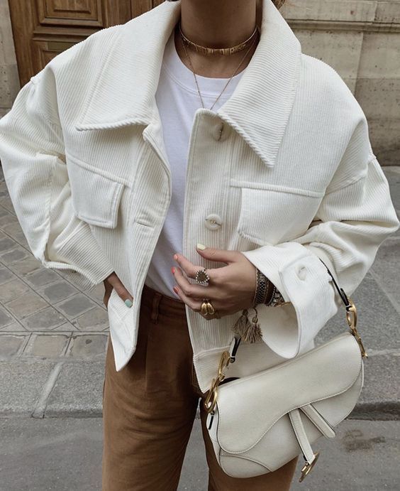 a white tee, brown suede trousers, a creamy corduroy cropped jacket, a creamy saddle bag