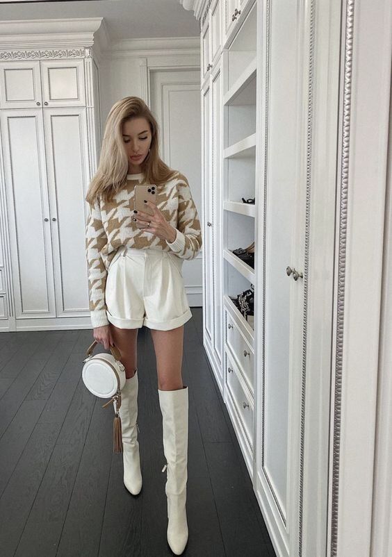 an elegant yet casual look with a tan and white houndstooth jumper, creamy shorts, creamy knee boots and a round bag