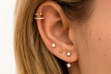 02 a chic and modern ear look done with a triple lobe piercing and a double helix piercing, with gold studs and hoops
