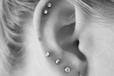 03 a double helix piercing done with elegant studs and four piercings in the lobe finished off with studs and an airy earring