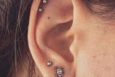 04 a delicately curated ear with a double lobe peircing with a couple of pretty studs, a triple helix piercing with matching studs
