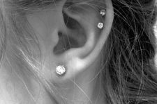 04 a lobe piercing and a double helix piercing accented with matching shiny studs look chic