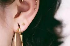 05 a double lobe, a rook, a triple helix, a conch piercing done with statement gold hoops and beautiful gold studs for a stylisha nd edgy look
