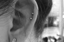 06 a stylish ear look with a double helix piercing with studs and a beautiful wing earring in the lobe