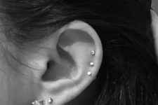 06 elegant ear styling with a double lobe piercing with large studs and a triple helix piercing with tiny matching studs is wow