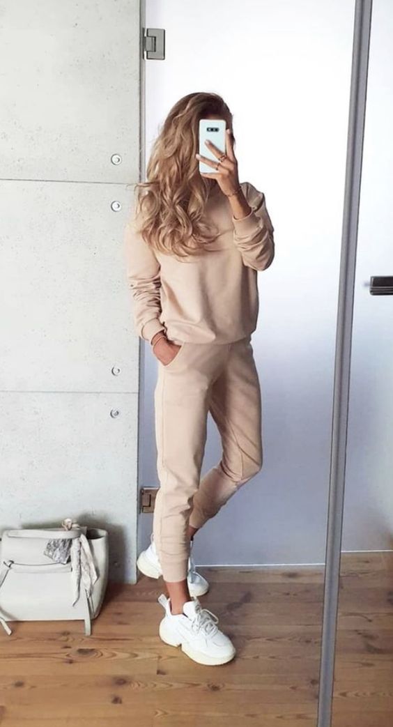 a tan sweatshirt and sweatpants, white trainers and a white tote compose a stylish look in neutrals