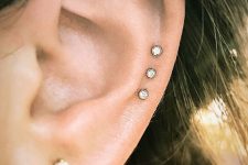 08 a triple helix piercing done with rhinestone studs and a beautiful gold stud in the lobe is a stylish idea for a modern and bold look