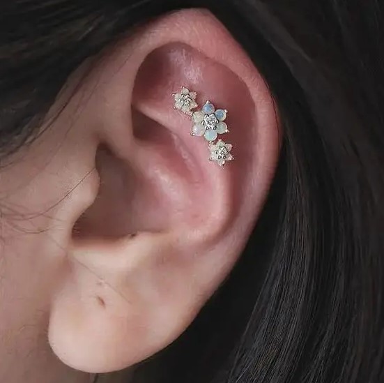 a gorgeous triple flat piercing done with matching opal studs of different sizes is a cool idea with a girlish feel