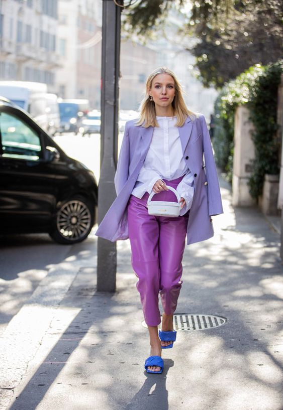 a white shirt, a Very Peri blazer, purple leather pants, blue mules and a white bag for a creative job look