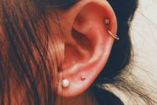 11 bold and catchy ear styling with a double lobe piercing and a double helix piercing with various studs and a hoop