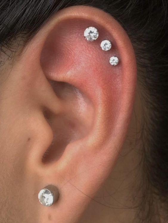 glam and chic ear styling with a stud in the love, a triple helix piercing with matching studs that differ in size