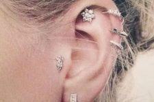12 glam ear styling with stacked helix, a lobe, a flat and a tragus piercing done with cool hoops and studs