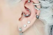 15 bold ear styling with stacked helix piercings and stacked lobe ones, with a daith piercing all done with cool hoops and studs