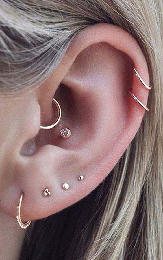 lovely minimalist ear styling with multiple lobe piercings, a daith, a conch piercing, a double helix, all done with pretty gold studs and hoops
