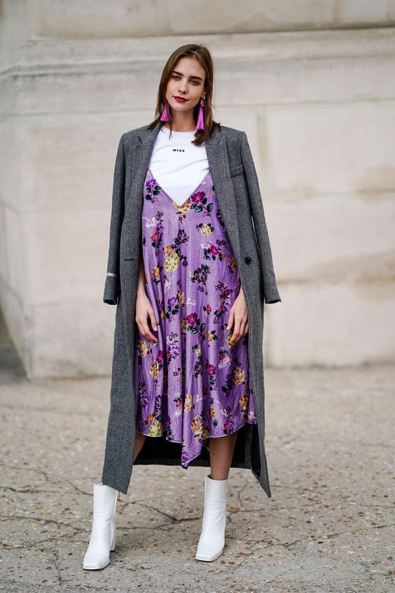 a lovely outfit with a white t-shirt, a Very Peri slip floral midi dress, white boots, a grey trench and hot pink tassel earrings