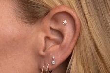 18 a cool stacked lobe piercing with gold hoops and studs plus a single flat piercing with a star stud for a dreamer