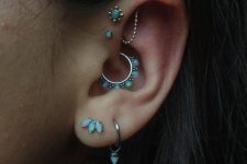 18 beautiful opal ear styling with a double lobe piercing, a daith piercing, a triple forward helix one, all done with matching studs and hoops