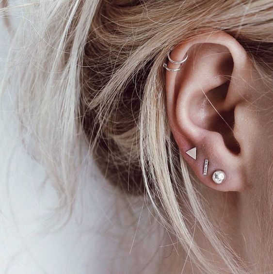 ultra-modern ear styling with a triple lobe piercing with chic gold studs and a double helix piercing done with hoops