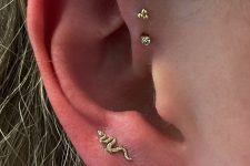 19 bold ear styling with stacked lobe piercings and a triple forward piercing done with tiny gold studs is amazing