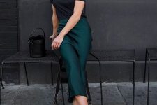 20 a black t-shirt, an emerald midi slip skirt, white and grey trainers and a black butcket bag for a romantic look