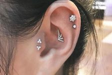 22 a little spiderweb stud in the upper conch, a double helix piercing and a double tragus one