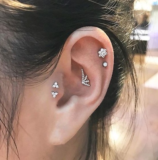a little spiderweb stud in the upper conch, a double helix piercing and a double tragus one