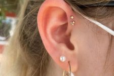 22 fab and chic ear styling with a double forward helix piercing done with pretty gold studs, a double lobe piercing with a pearl stud and a whimsy earring
