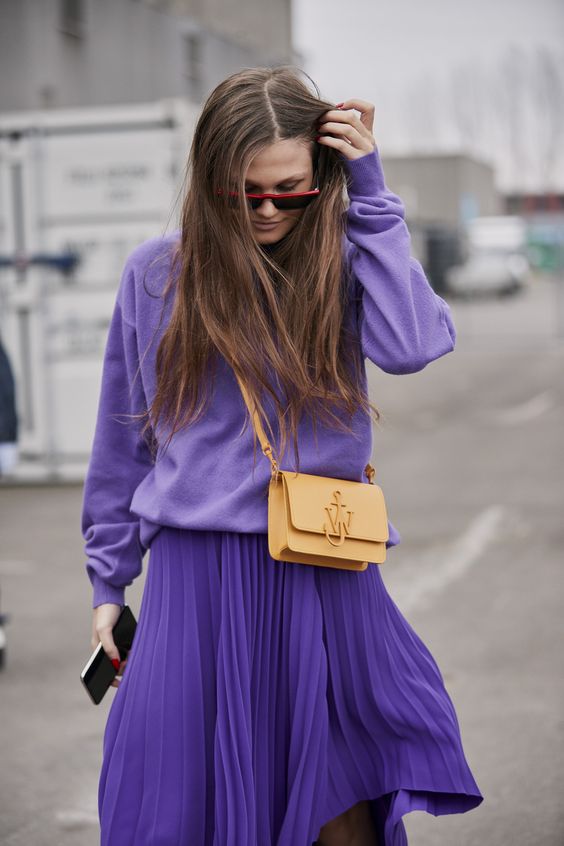 a bold monochromatic look with a Very Peri sweatshirt, a matching pleated skirt, a tan bag for spring