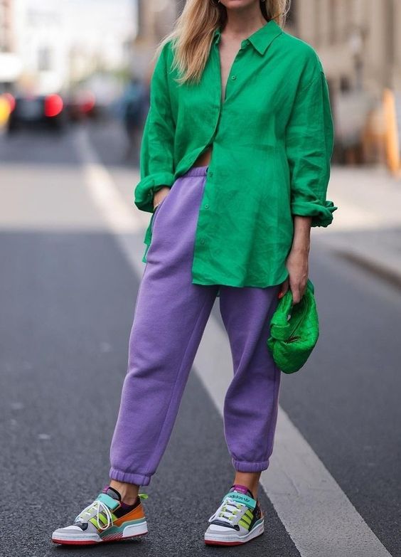 a bright and comfortable outfit wiht an emerald shirt, an emerald mini bag, Very Peri sweatpants and colorful trainers