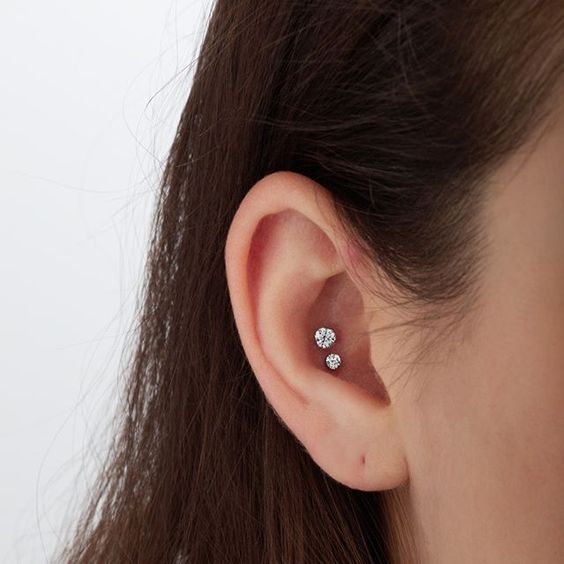 a lovely and delicate double conch piercing done with matching but different in size rhinestone studs is amazing
