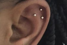 25 a triple flat piercing done with matching gold studs and a large earring in the lobe for a bold and super chic look