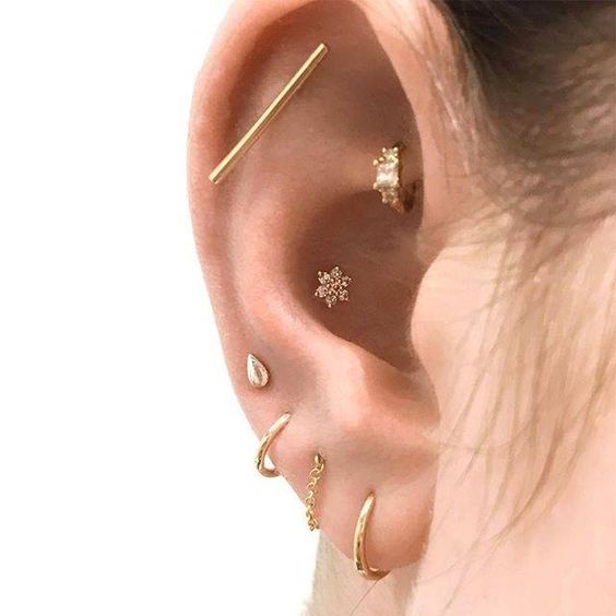 a modern look with a stacked lobe, a flat, a rook and a conch piercing, all done with beautiful studs and hoops