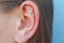 27 a triple flat piercing with two rhinestone and a single floral stud is a cool and stylish idea to rock